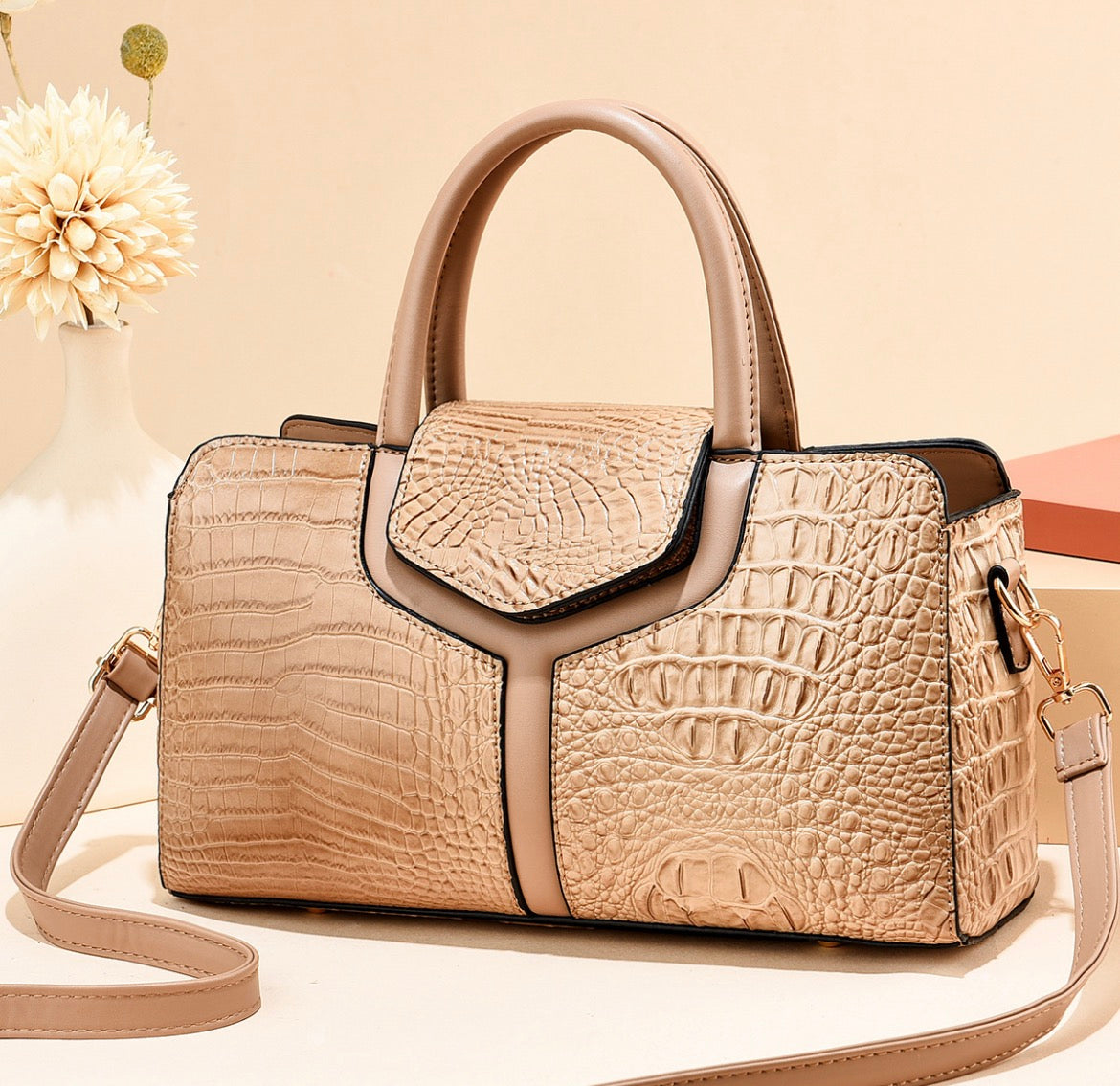 Beige crocodile-style textured satchel handbag with rounded twin handles, smooth beige trim, and shoulder strap