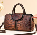 Brown crocodile-style textured satchel handbag with dark brown twin handles, smooth trim, and shoulder strap
