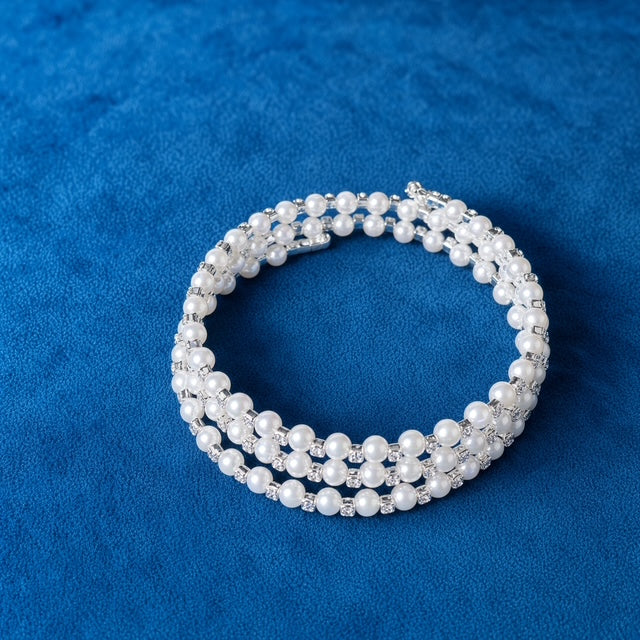 Triple Strand Pearl and Rhinestone Wrap Bracelet on blue velvet background
