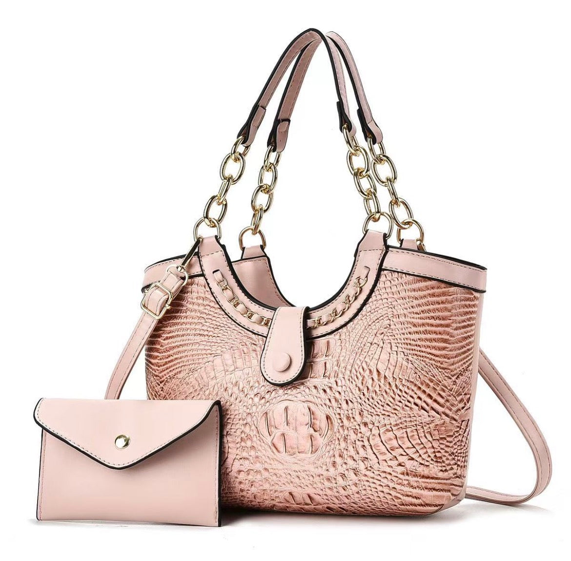 Blush pink crocodile-style handbag with gold-tone chain-link handles and shoulder strap, pictured beside a pink envelope pouch