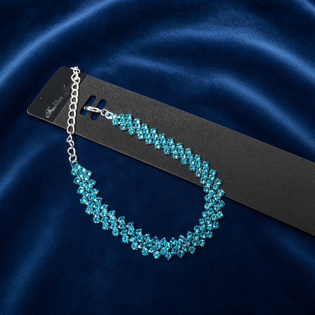 Teal Rhinestone Tennis Bracelet on black jewelry card against blue satin